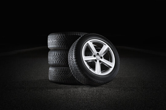Car tires with a great profile on asphalt isolated on black background. Set of summer or winter tyres.