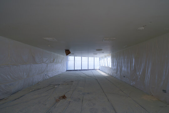 Empty hotel interior under construction with protective sheeting