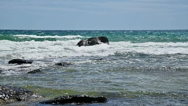 Sea waves crashing against rocks in coastal waters