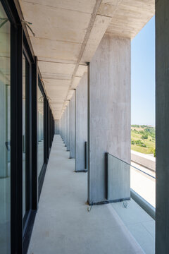 Modern hotel corridor with concrete columns and glass facade