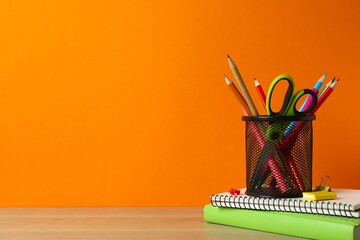Black holder with stationery on wooden table © Sunlight