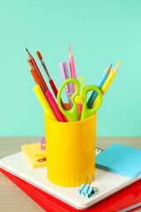 Yellow holder with stationery on wooden table © Sunlight