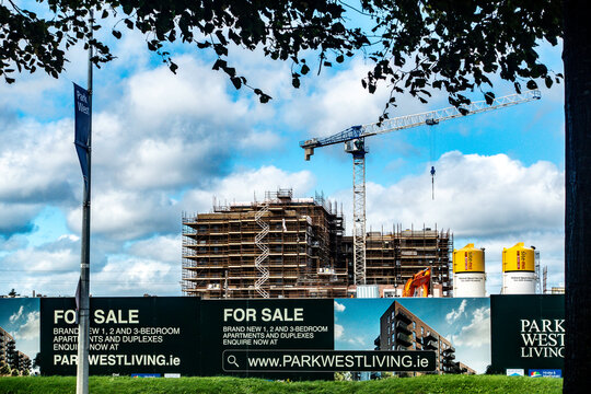 Park West residential development construction site with scaffolding, tower crane, and advertising hoardings in Dublin, Ireland.