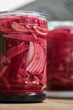 Pickled red onion in glass jar with aromatic spices