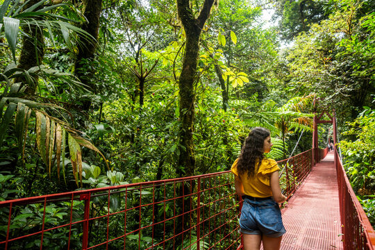 Woman crossing suspension bridge in Costa Rica rainforest