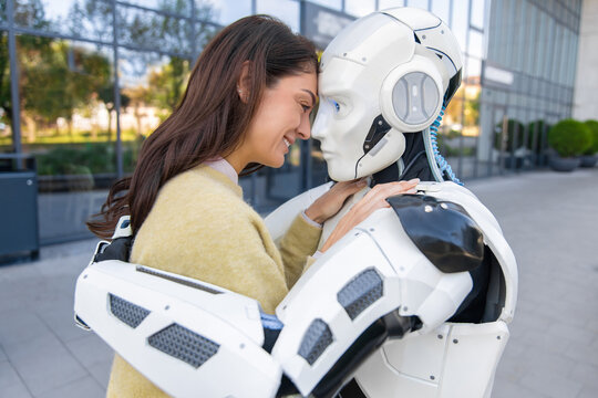 Woman standing face to face in embrace with humanoid robot