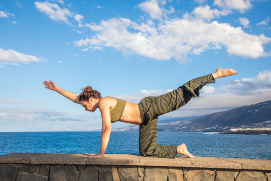 Woman practice yoga by the sea in Tenerife summer