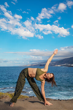 Woman practice yoga pose by sea in Tenerife