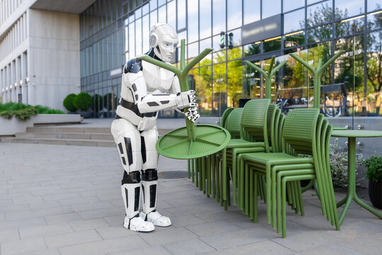Bipedal humanoid robot carrying green plastic table
