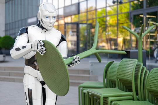 Cybernetic android lifting green outdoor table