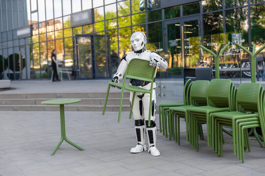 Futuristic robot holding green chair