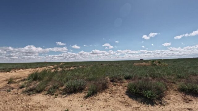 Forward movement along dirt path through open grassland landscape