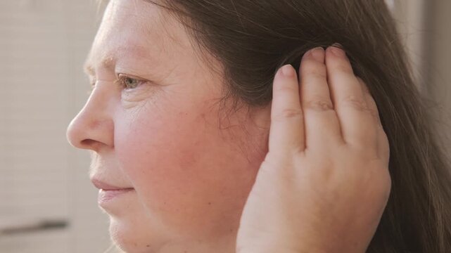 modern behind-the-ear hearing aid on woman's ear improve auditory perception and communication, audiological hearing support, sound device, healthcare assistance, Technological progress ENT medicine