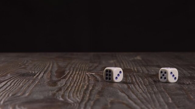 Close-up of a wooden table with dice flying out of frame