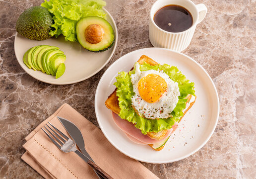 Avocado sandwich with lettuce ham and cucumber on plate