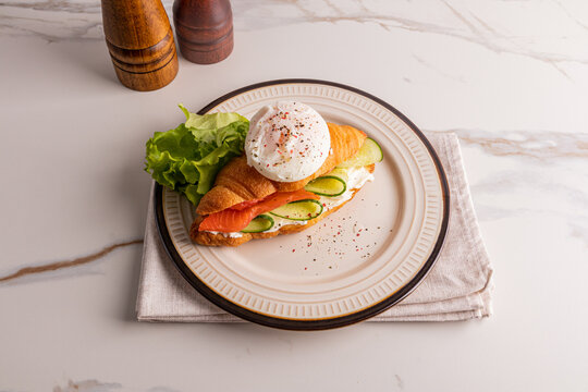 Croissant sandwich with salmon cucumber lettuce and cream cheese