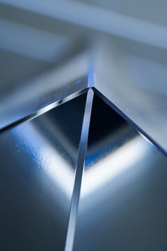 Abstract blue metallic pyramid with reflective geometric surface