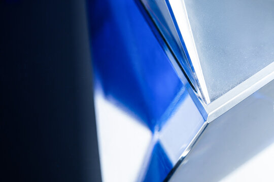 Abstract blue glass prism with geometric light reflection