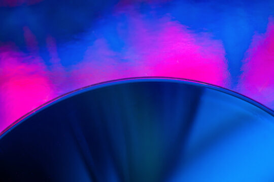 Futuristic blue disc against vibrant pink smoke background