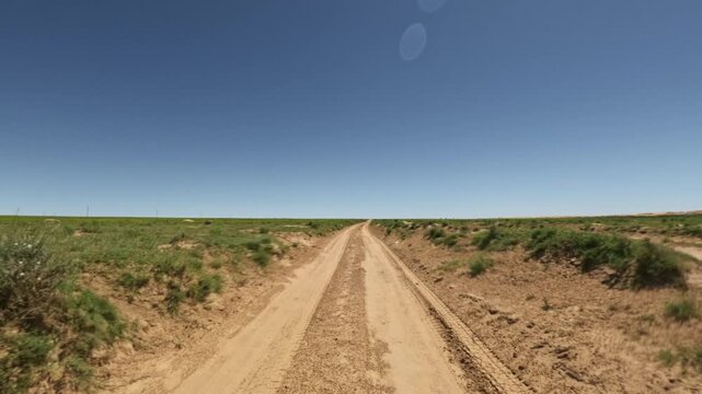 Forward movement along a dirt road in grassy terrain