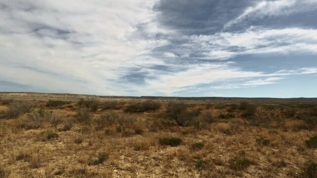 Moving forward across a flat arid desert landscape