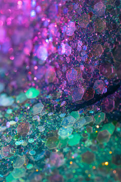 Iridescent hexagonal glitter texture with colorful bokeh background