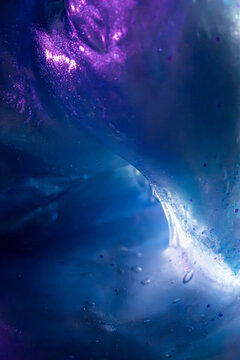 Abstract blue and purple liquid texture with luminous swirl
