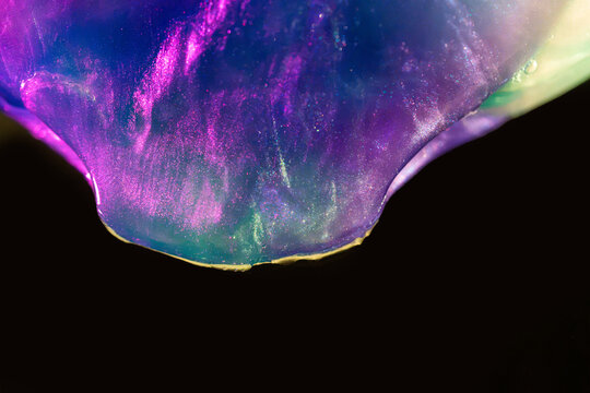 Iridescent soap bubble surface against black background