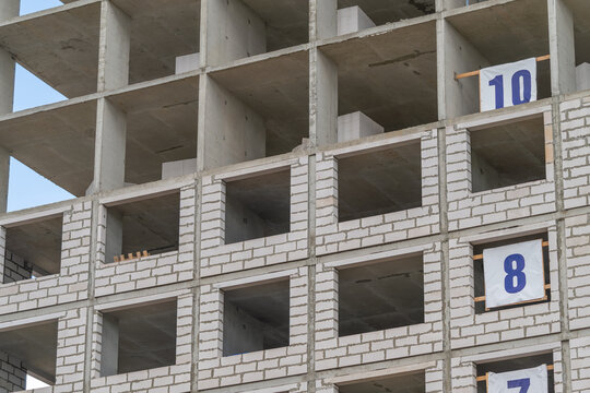 Construction process of a rising building shows concrete structure nearing completion under bright blue sky