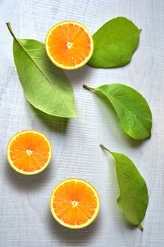 Fresh orange fruit with slices and leaf on white background