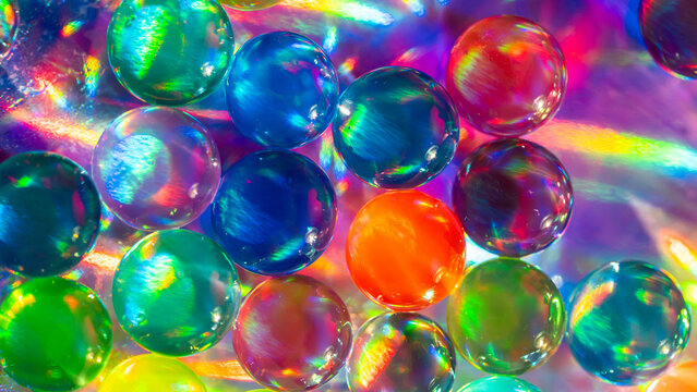 Colorful glass marble abstract background with rainbow reflections