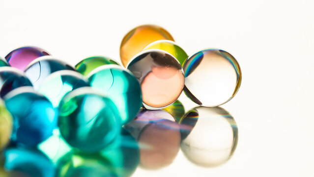 Colorful glass marble with reflection on white background