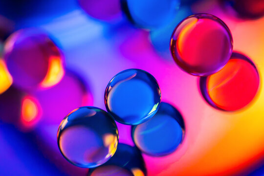 Colorful glass spheres on vibrant neon abstract background