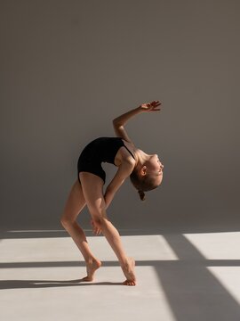 Little gymnast posing on a white background. 