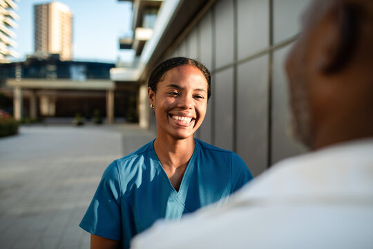 Smiling nurse with patient outside hospital