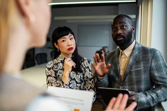 Coworkers discussing project in modern office