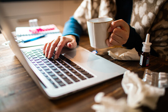Sick person working on laptop at home