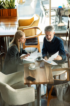 Business colleagues reviewing reports at cafe