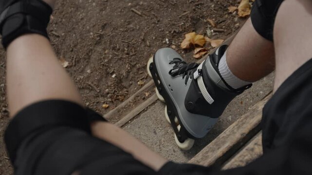 A skater sitting on a bench after a long session of skating in Battersea Park, London, slow motion