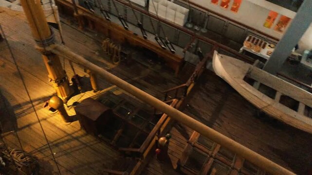 High-angle view of the historic wooden deck, rigging, and masts of the sailing ship Ebe preserved inside the naval pavilion at Milan Science Museum in Italy.


