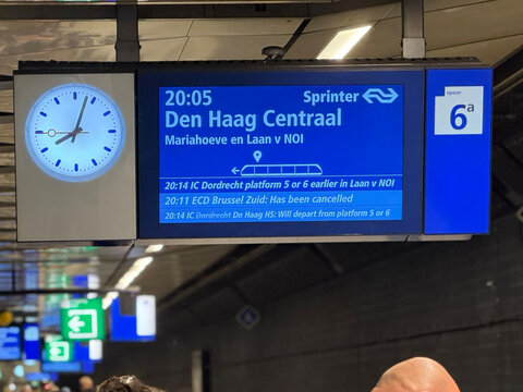 Amsterdam, Netherlands - July 6, 2026: A board displays train info and cancellations for destinations like Den Haag Centraal.