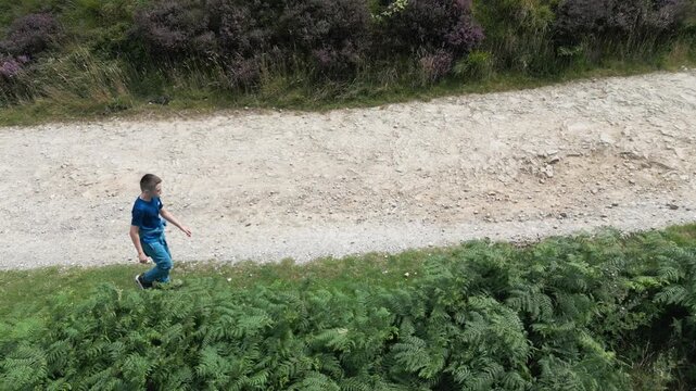 Child walks along gravel path bordered by greenery. Marsden Butterley & Blakeley Reservoirs