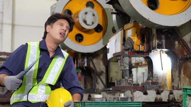 Tired worker safety vest operating industrial press machine inside factory, metalworking mechanic technician operator focused manufacturing safety, production, reflective gear, gloves, yellow helmet