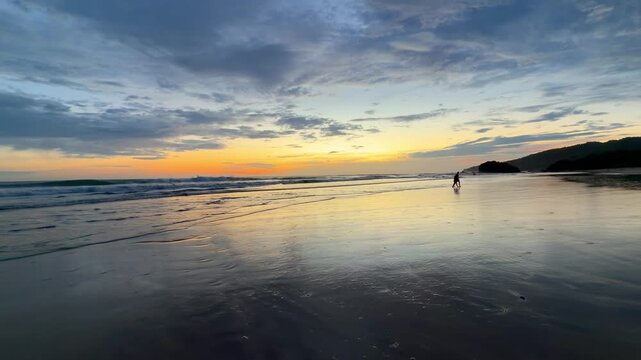 Romantic couple walking on a serene beach at sunset