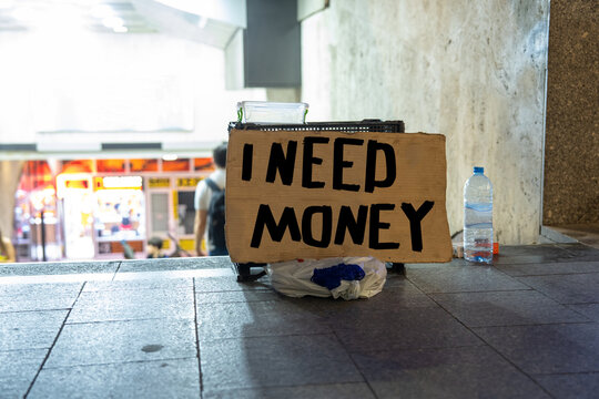 The cardboard sign says Help with money