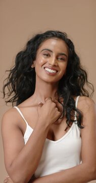 Vertical video: Indian woman posing in set tilting head back touching neck pulling white cami strap