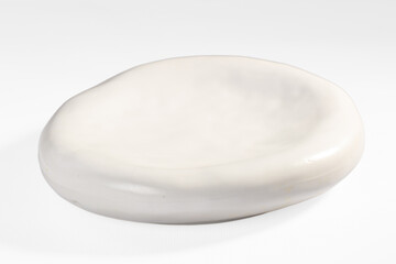 Smooth white ceramic dish with organic oval shape and glossy finish on plain white background