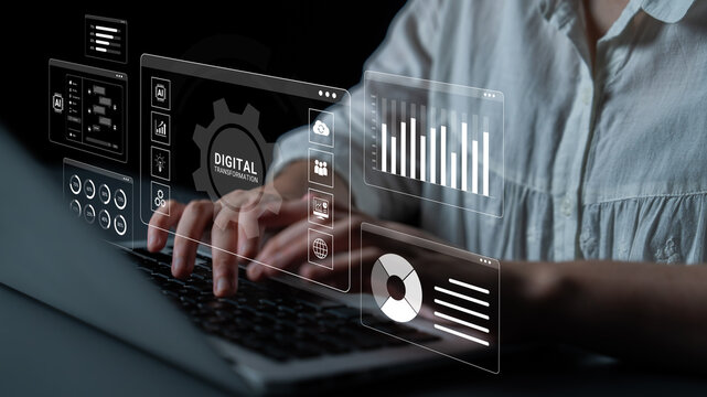 Digital Transformation Concept with Overlaid Data Analytics on Laptop, Person Working in Modern Office with Futuristic Interface Elements Displaying Charts and Information. Glyphic.