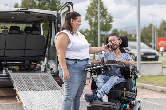 Wheelchair user enjoying a phone conversation with support from an assistant after accessible transport. Personal assistance and inclusive mobility.
