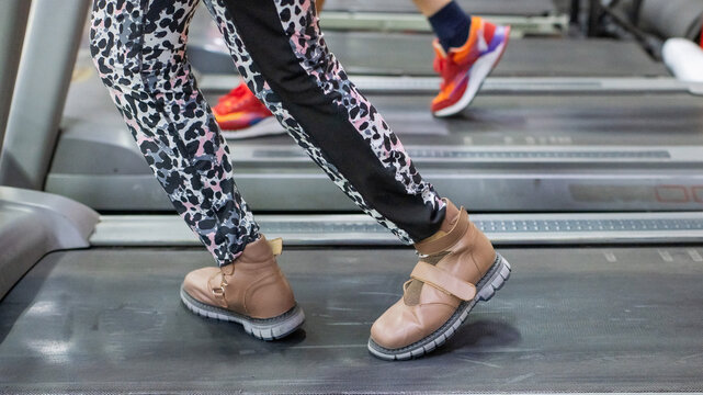 A woman with cerebral palsy walks on a treadmill. 